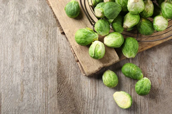 Basket with fresh Brussels sprouts on wooden background — Stock Photo, Image