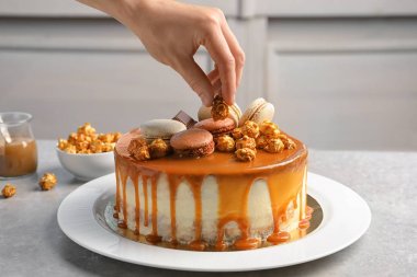 Kadın masada karamelli pasta süsleme