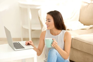 Masada kapalı dizüstü bilgisayar kullanan genç kadın