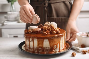 Kadın mutfakta masada lezzetli karamelli pasta süsleme