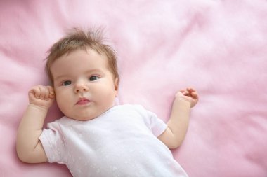 Evdeki yatakta uzanmış tatlı bir bebek.