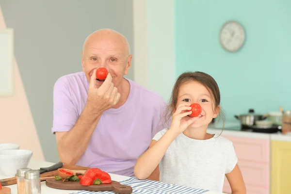 Starší muž vaření spolu s jeho vnučka — Stock fotografie