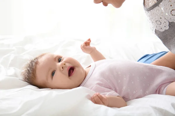 Niedliche kleine Baby und Mutter auf dem Bett zu Hause — Stockfoto