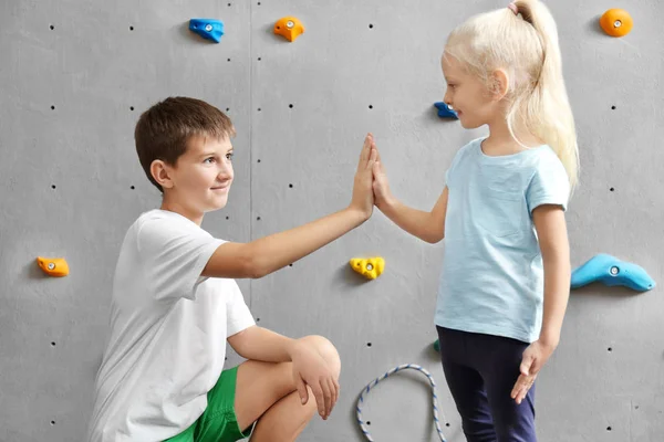 Liten flicka och ung pojke i klättring gym — Stockfoto