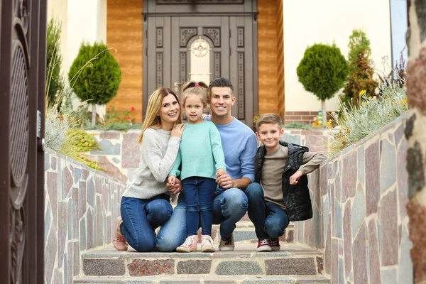 Happy family near their house entrance