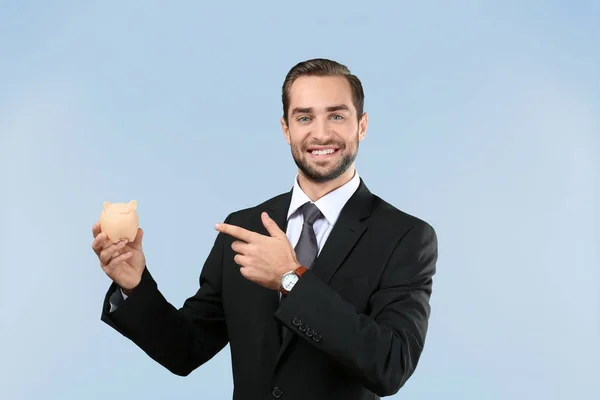 Hombre de negocios guapo con alcancía — Foto de Stock