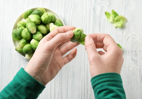 Woman with Brussels sprouts in kitchen — Stock Photo, Image