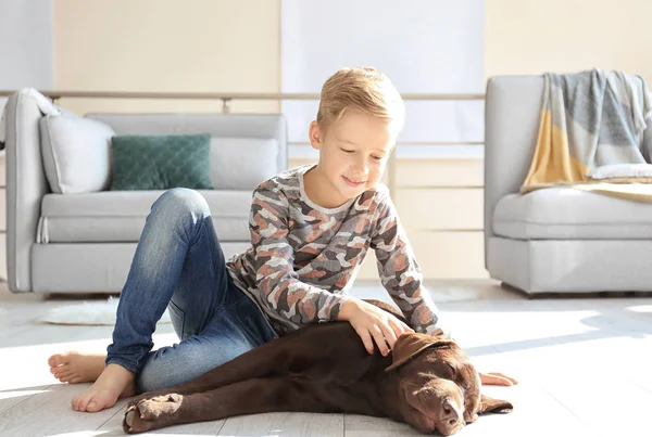 Söt liten pojke med hund på golvet hemma — Stockfoto