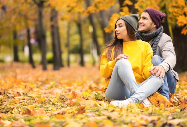 Junges Paar sitzt im Herbstpark auf dem Boden — Stockfoto