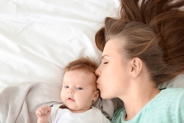 Ibu muda dan bayi lucu di tempat tidur di rumah — Stok Foto