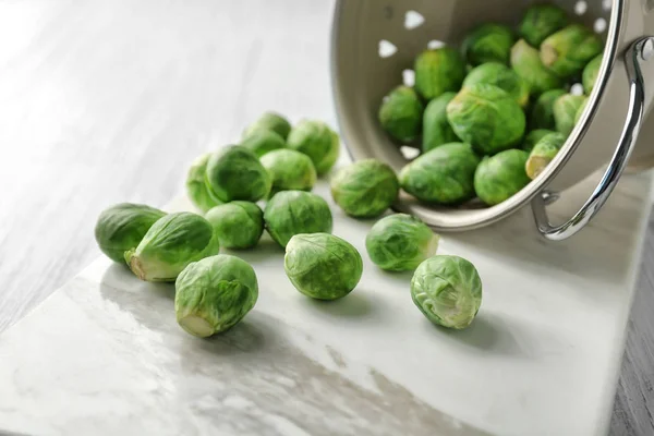 Vergiet met verspreide spruiten op tafel — Stockfoto