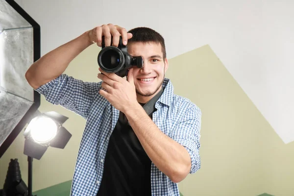 Jovem fotógrafo trabalhando em estúdio profissional — Fotografia de Stock