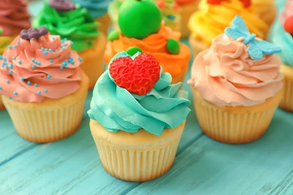 Tasty colorful cupcakes on wooden background — Stock Photo, Image