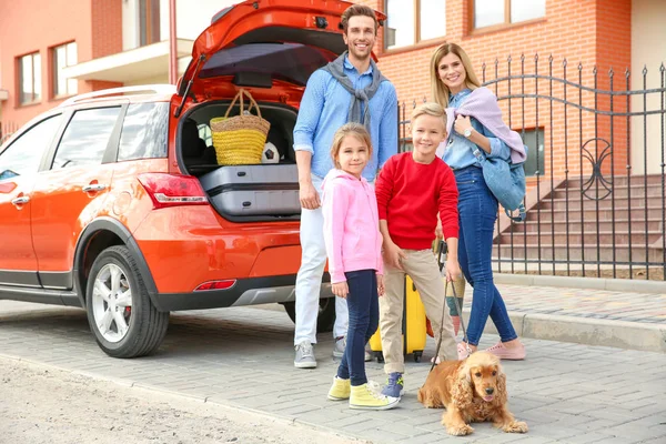 Jeune famille avec enfants et chien près de la voiture — Photo