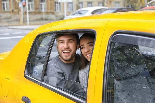 Szczęśliwa Młoda para na tylnym siedzeniu samochodu taxi — Zdjęcie stockowe