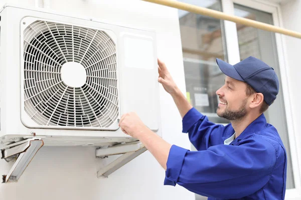 technician repairing air conditioner