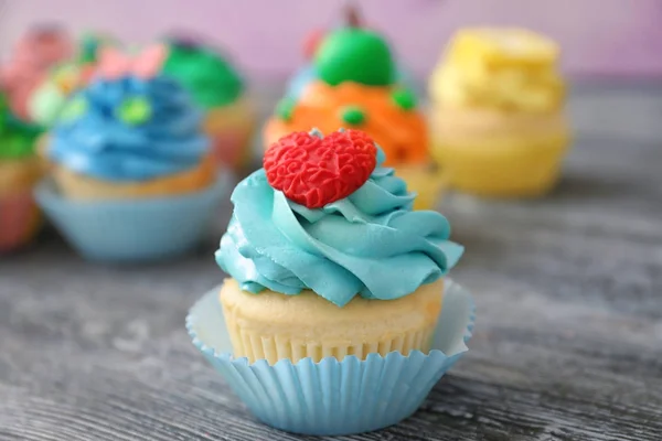 Tasty colorful cupcake on wooden table — Stock Photo, Image