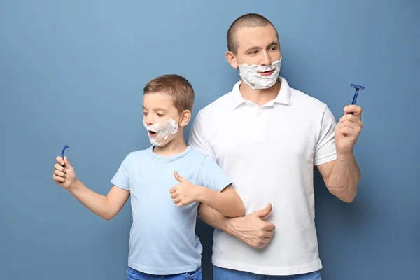 Vader en zoon scheren op kleur achtergrond — Stockfoto