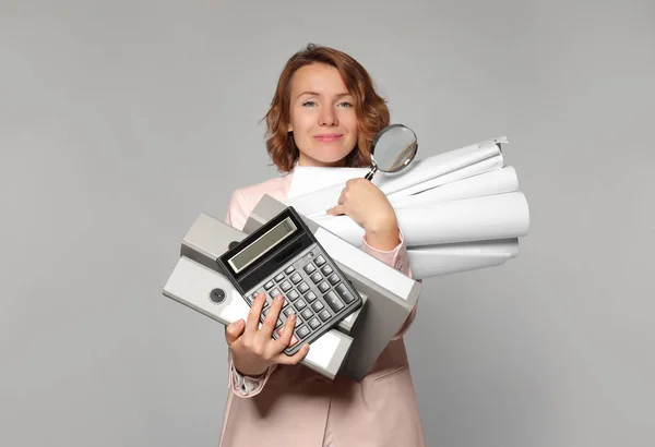 Managerin mit verschiedenen Bürokram auf grauem Hintergrund — Stockfoto