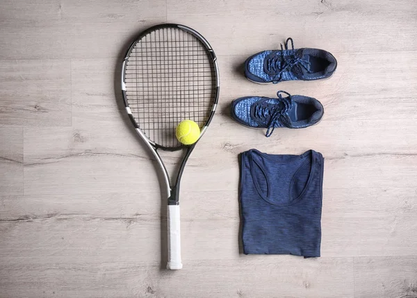 Raqueta de tenis, pelota, ropa y zapatos sobre fondo de madera — Foto de Stock