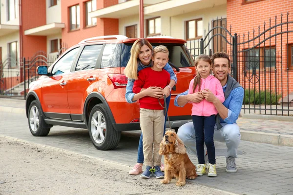 Ung familj med barn och hund nära bil — Stockfoto