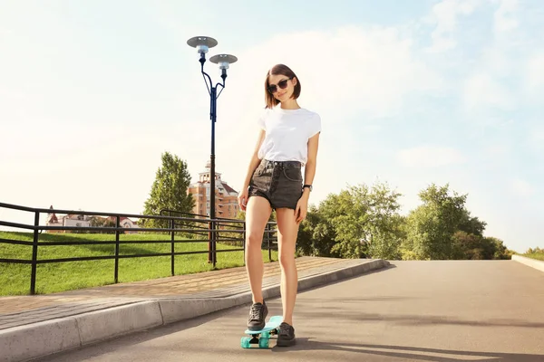 Хипстерская девушка катается на скейте в парке — стоковое фото