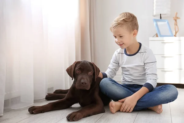 Mignon petit garçon avec chien sur le sol à la maison — Photo