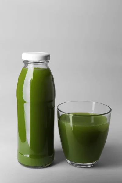 Botella y vaso con jugo sobre fondo claro — Foto de Stock