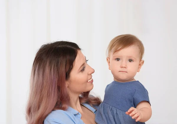 Jovem mãe com bebê no fundo claro — Fotografia de Stock