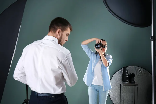 Giovane uomo in posa per fotografo professionista in studio — Foto Stock