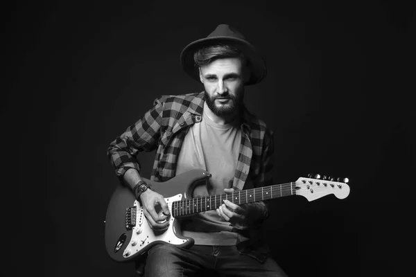 Junge hübsche Musikerin spielt Gitarre auf schwarzem Hintergrund — Stockfoto