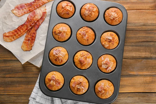 Lekkere spek muffins in schimmel op tafel — Stockfoto