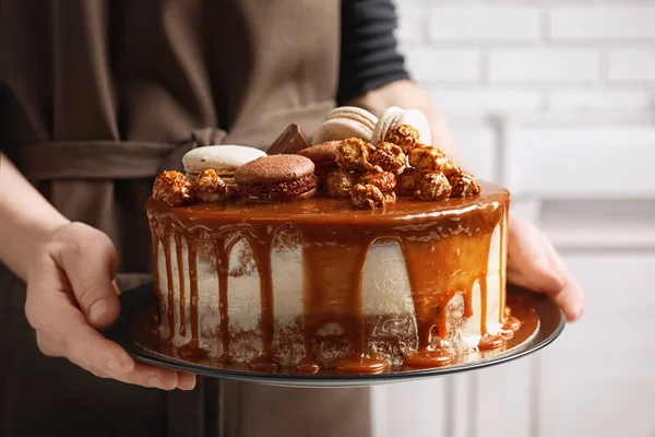 Frau hält Karamellkuchen in der Hand — Stockfoto