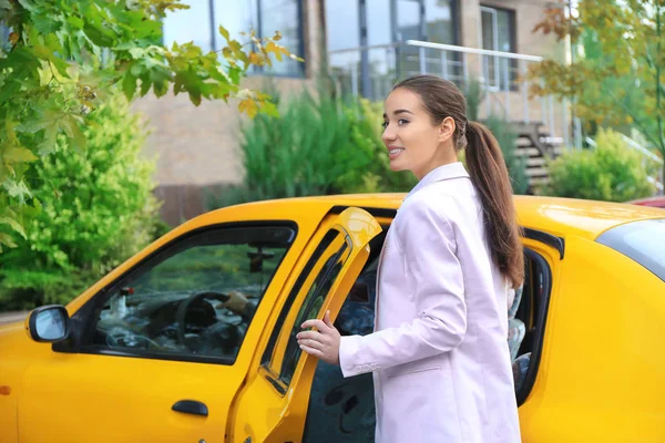 Jovem empresária entrando em táxi carro — Fotografia de Stock