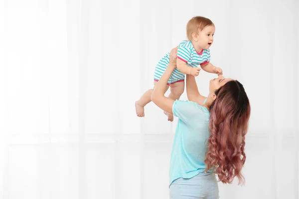 Jovem mãe com bebê no fundo claro — Fotografia de Stock