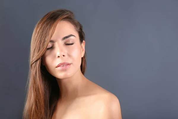 Belle jeune femme avec des extensions de cils sur fond gris — Photo