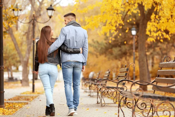 秋の日に公園で歩く若いカップル — ストック写真