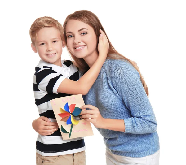 Mujer joven con su hijo pequeño y tarjeta de felicitación para el Día de la Madre sobre fondo blanco —  Fotos de Stock