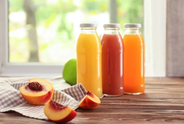Бутылки с фруктовыми соками на столе внутри помещения — стоковое фото