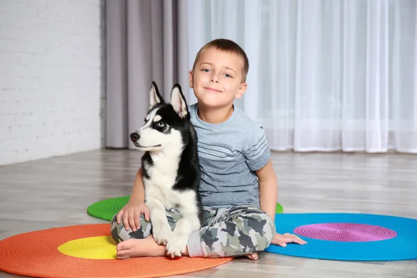 Mignon chiot husky et petit garçon sur le sol à la maison — Photo