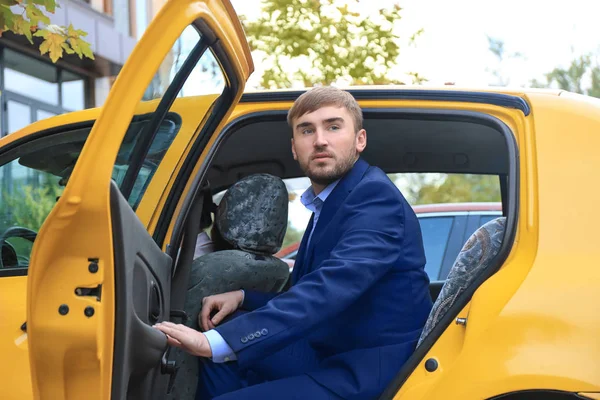 Jeune homme d'affaires sortir de la voiture de taxi — Photo