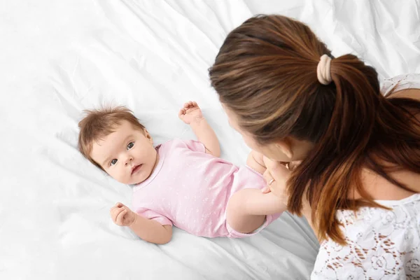 Mutter spielt zu Hause mit süßem Baby im Bett — Stockfoto