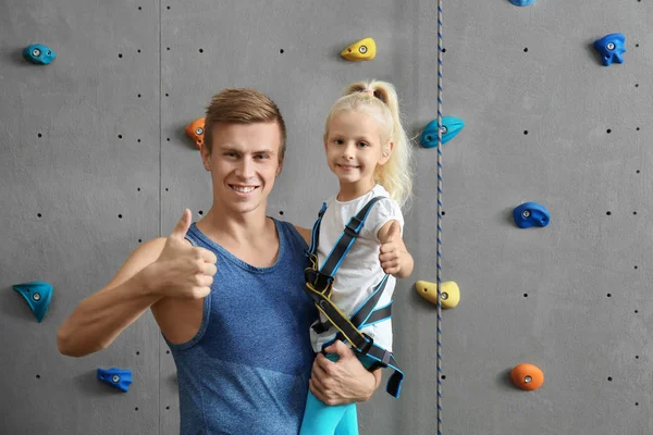 Istruttore che tiene la bambina in palestra di arrampicata — Foto Stock
