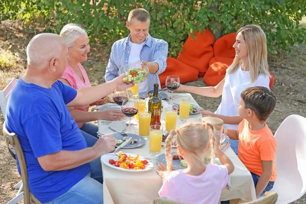 Lykkelig familie som har grillfest utendørs – stockfoto