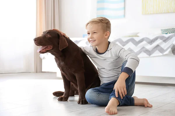 Menino bonito com cão no chão em casa — Fotografia de Stock