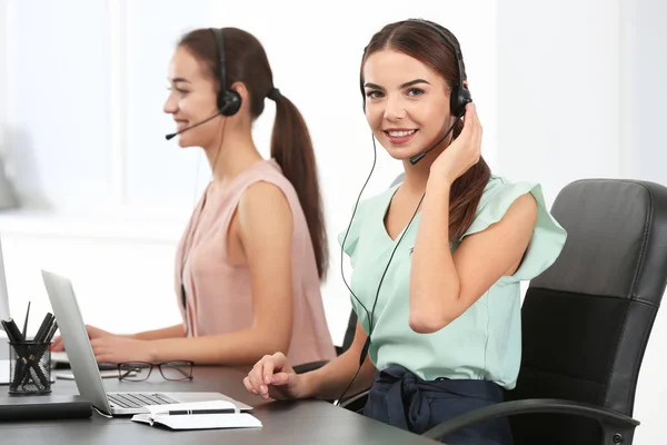 Femmes responsables de la consultation avec écouteurs au bureau — Photo