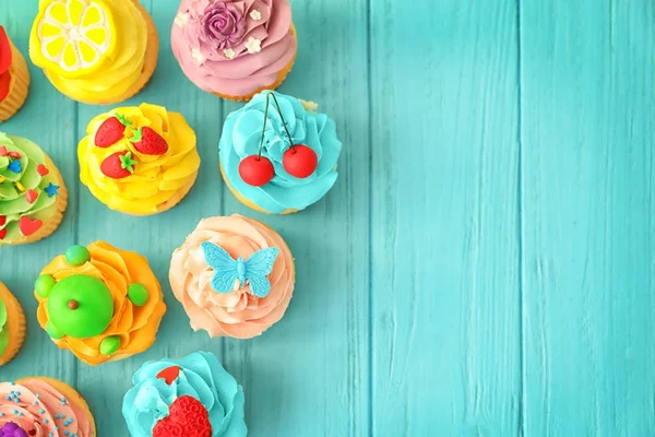 Leckere bunte Cupcakes auf Holz Hintergrund — Stockfoto