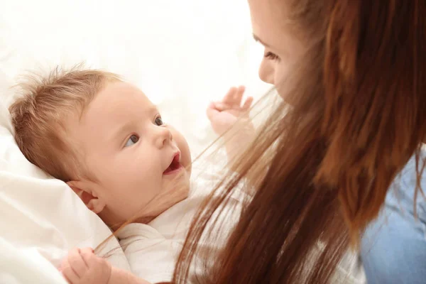 Jovem mãe e bebê bonito na cama em casa — Fotografia de Stock