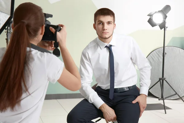 Young man posing for professional photographer in studio — Stock Photo, Image