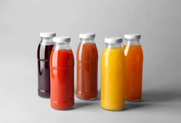 Bottles with juices on light background — Stock Photo, Image